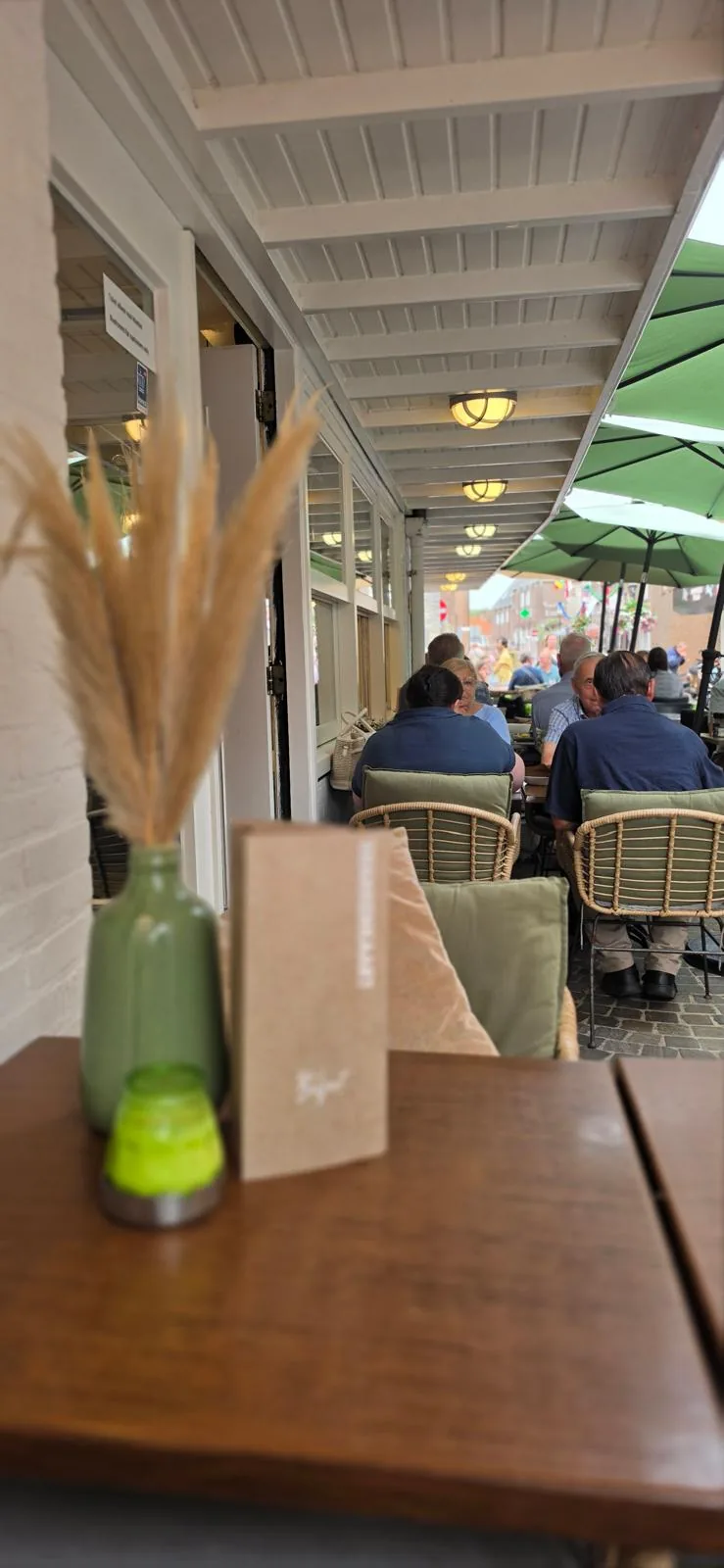 Zicht vanaf een tafel binnen op het terras